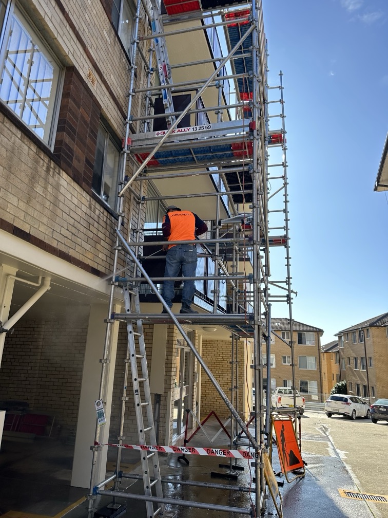 Worker on a ladder on a building