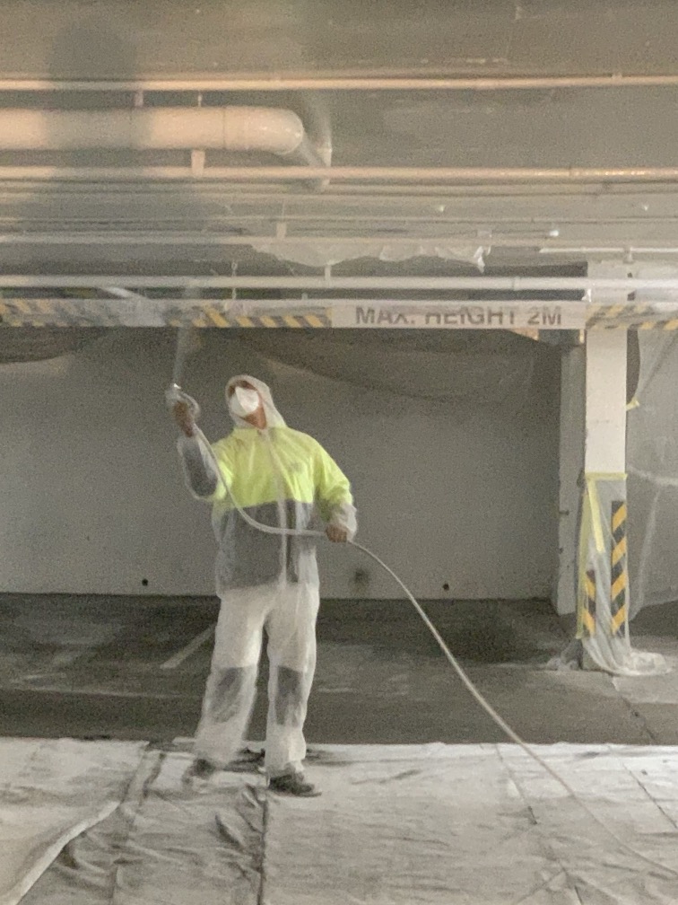 Worker painting underground garage