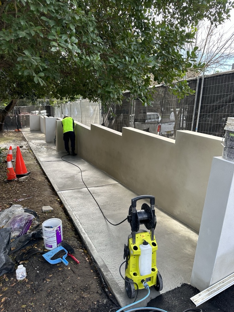 Worker wearing a safety vest and decorating a concrete surface